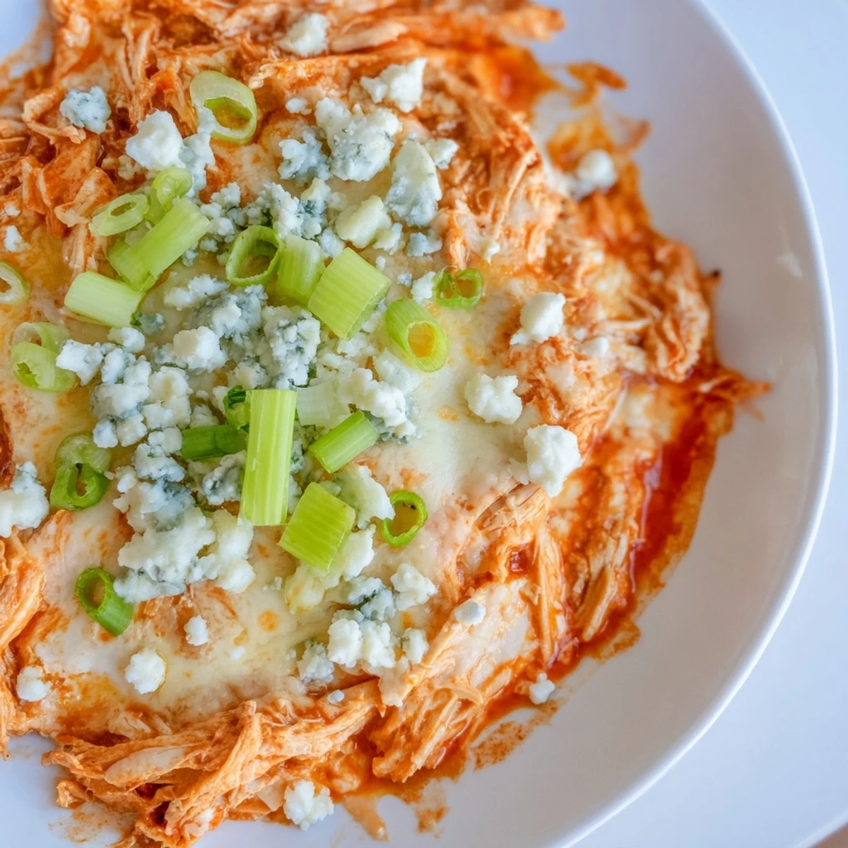Steaming, bubbly Spicy Buffalo Chicken Dip served with crisp celery sticks and crunchy tortilla chips for dipping.