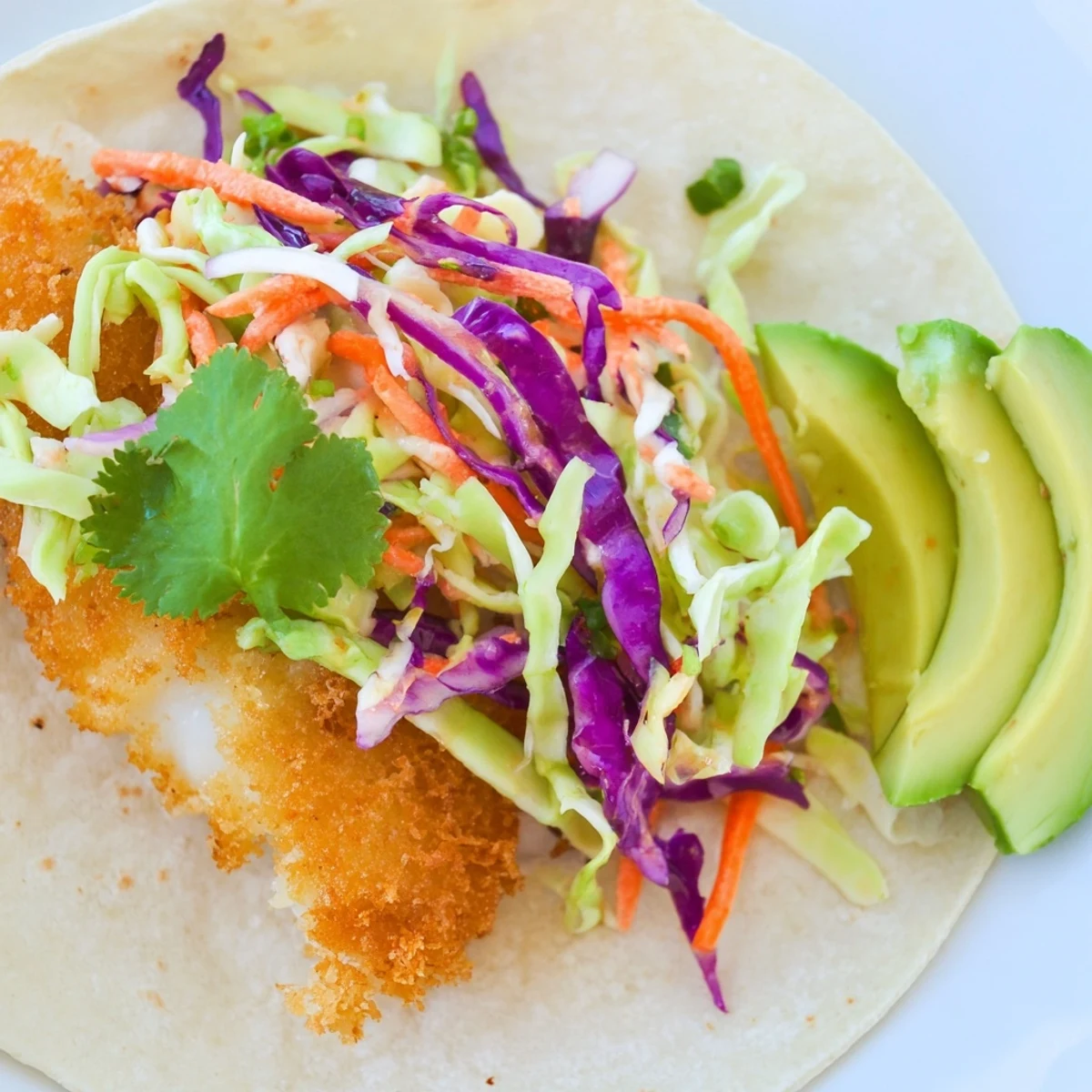 Crispy Fish Tacos with Cabbage Slaw and Lime feature golden fried fillets, creamy slaw, and avocado slices on warm tortillas.  