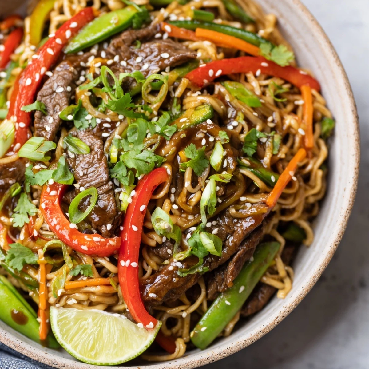 Colorful platter of Spicy Beef Noodles with Vegetables, loaded with snap peas, julienned carrots, and aromatic garlic-ginger flavors.