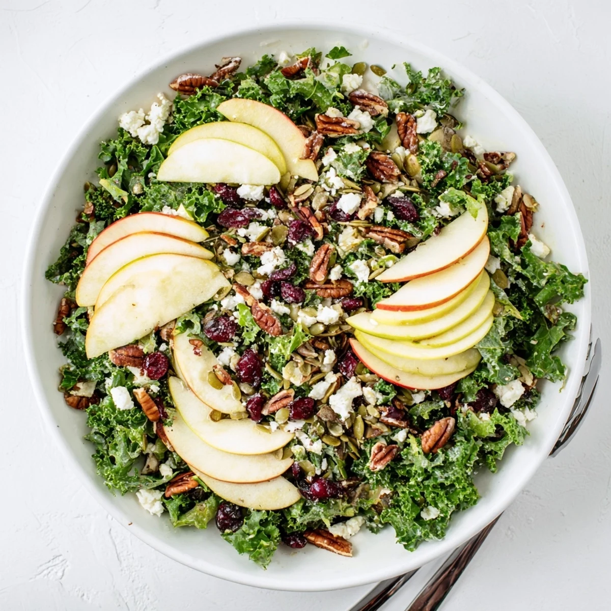 Hearty Winter Kale Salad tossed with crisp kale, dried cranberries, and a sweet maple-Dijon vinaigrette.