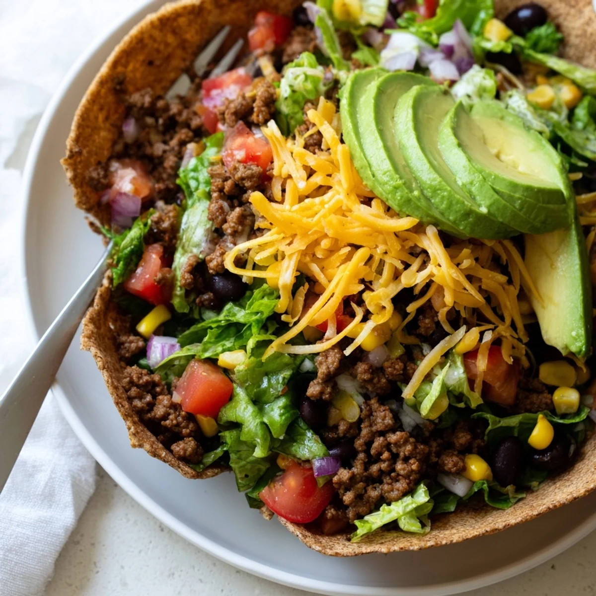 Hearty and colorful, this Beef Taco Salad features a crunchy baked tortilla shell, savory beef filling, and all the classic toppings for a satisfying meal.