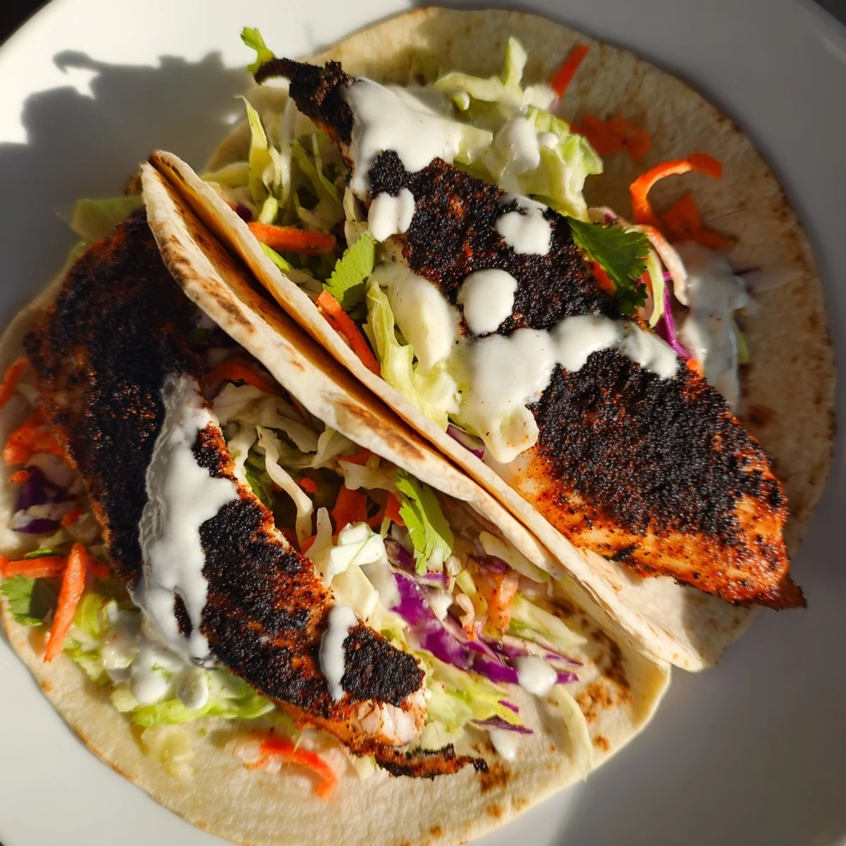 Sizzling cast-iron fish meets soft corn tortillas in these vibrant Louisiana Blackened Fish Tacos, finished with a spicy, smoky sauce.