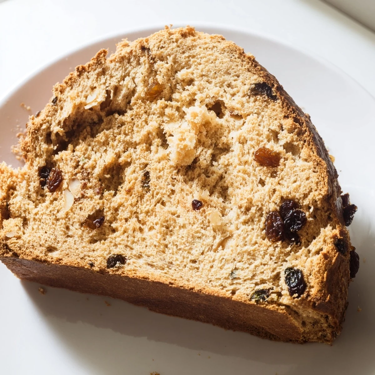 Slices of whole wheat Irish soda bread with currants served with butter and honey, ideal for afternoon snacks.