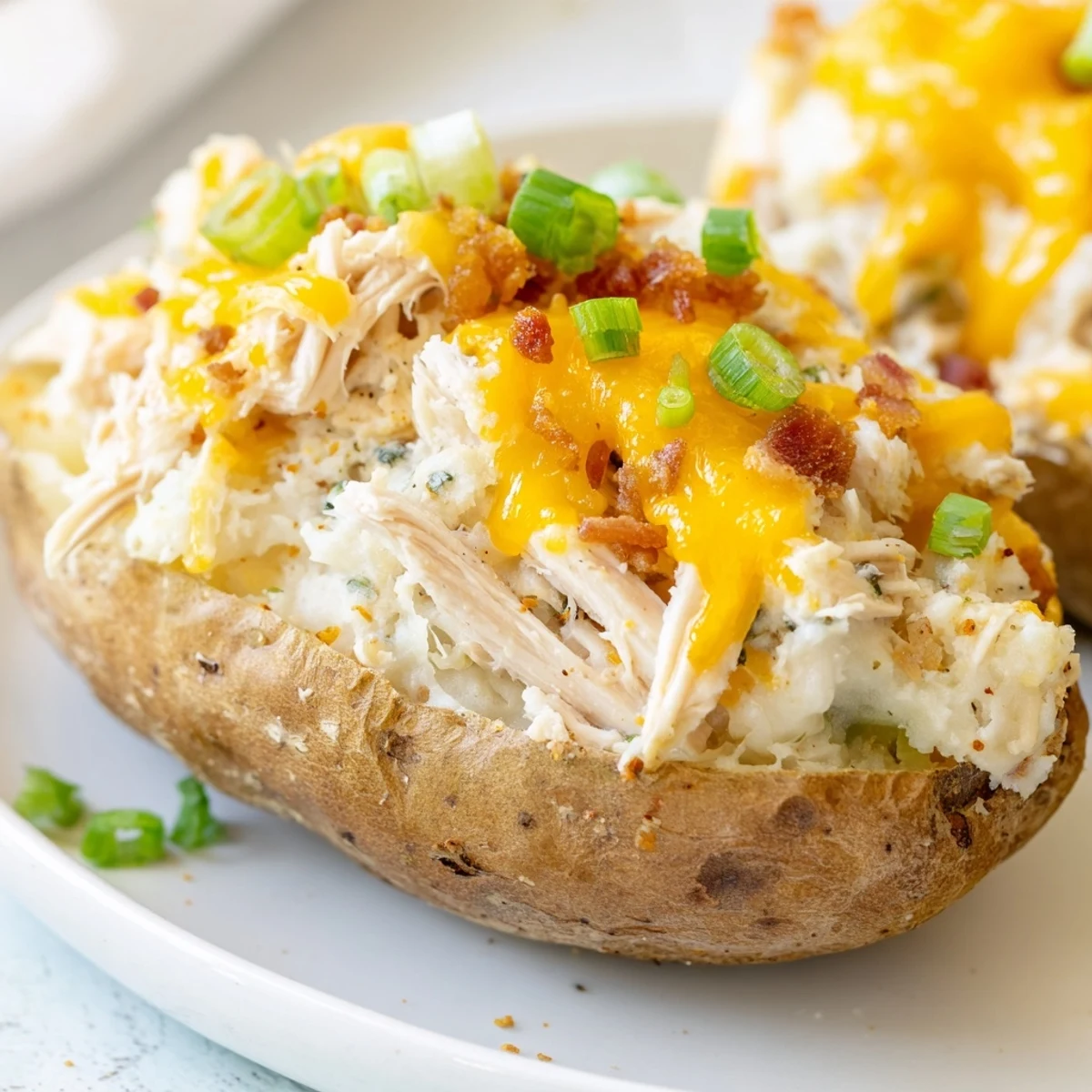 Crispy baked russet potatoes loaded with savory shredded chicken and melty cheddar cheese.