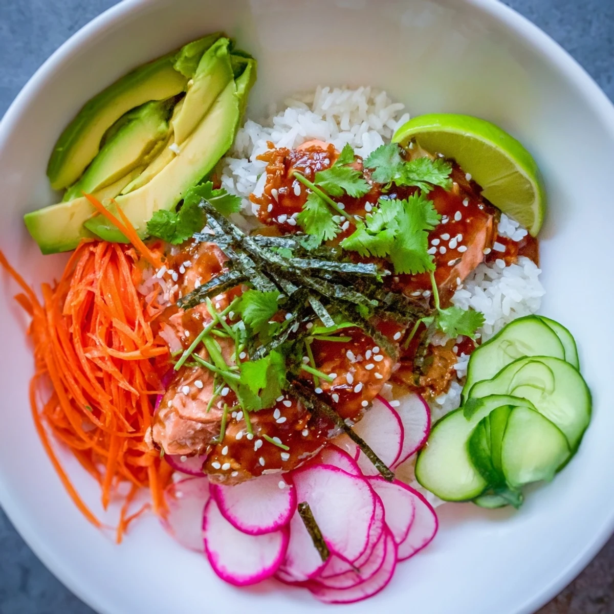 Tender teriyaki-glazed salmon nestled on rice with crunchy cucumber, radishes, and creamy avocado slices. 