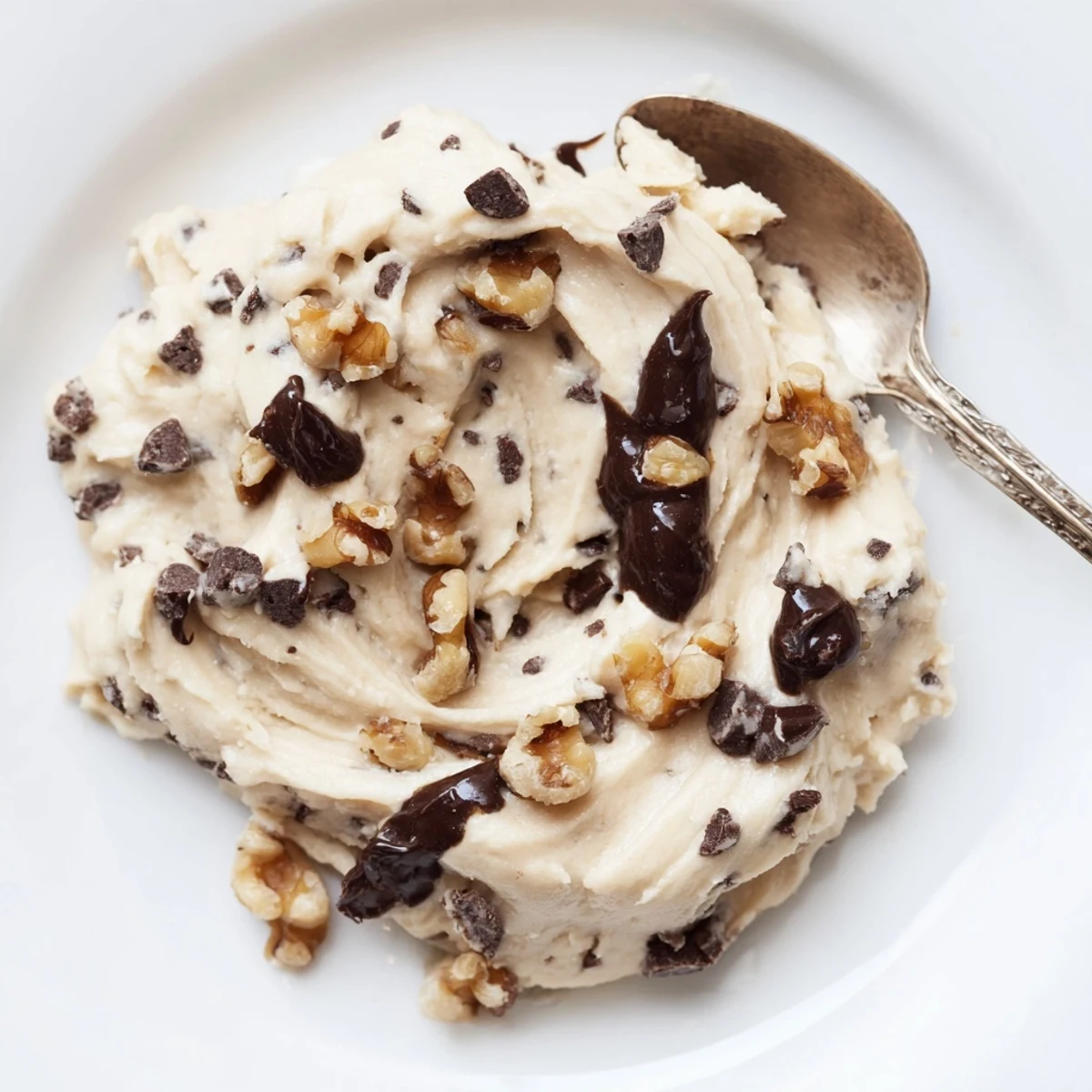 A healthy bowl of Guilt Free Greek Yogurt Cookie Dough topped with white chocolate chips and nuts, perfect for snacking.