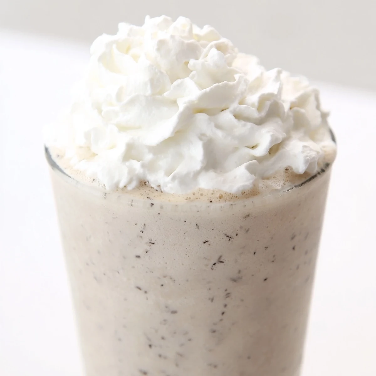Two tall glasses of creamy Starbucks Vanilla Bean Frappuccino topped with fluffy whipped cream.