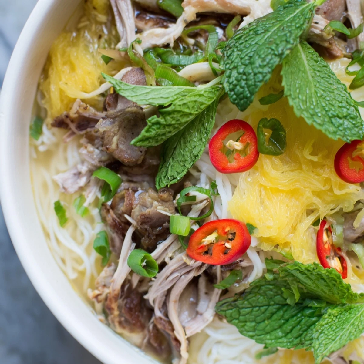 Colorful Bun Thang bowl with tender chicken, herbs, and a rich aromatic broth ready to serve.