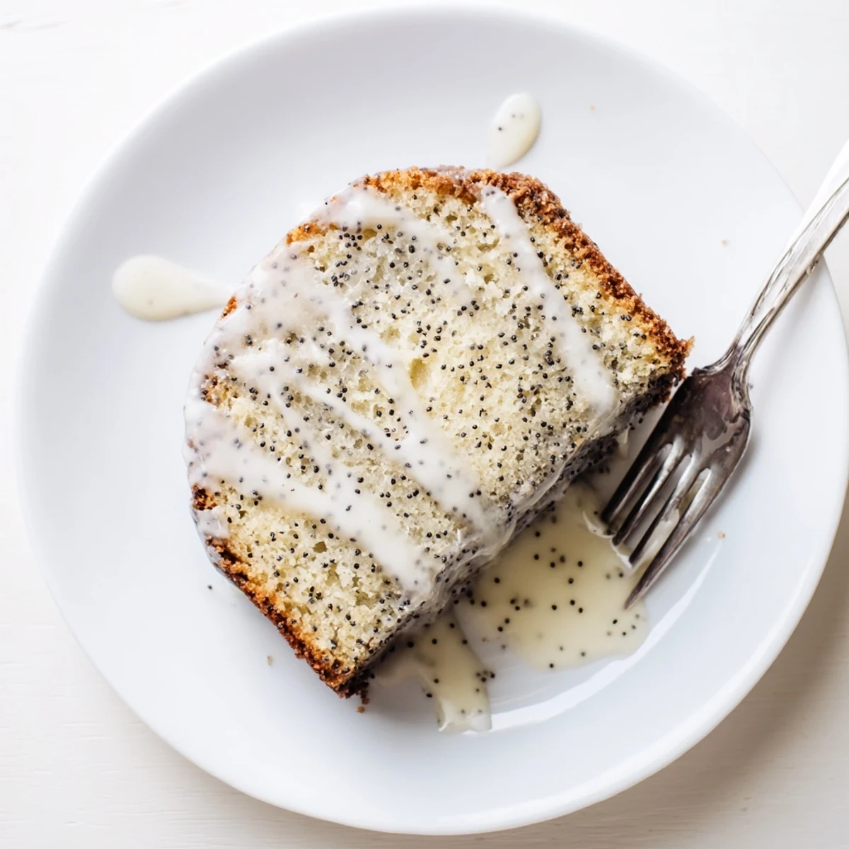 Served on a checkered tablecloth, this moist Lemon Poppy Seed Cake offers a bright citrus flavor and crunchy poppy seed texture.