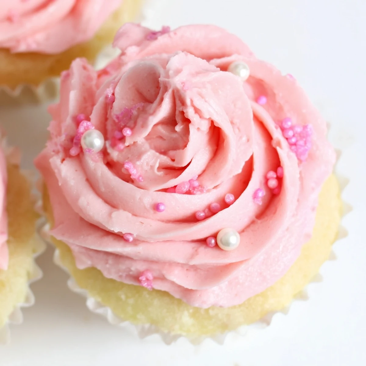 Freshly baked Girl Baby Shower Cupcakes with pink buttercream swirls and edible pearl decorations on a soft pastel background.