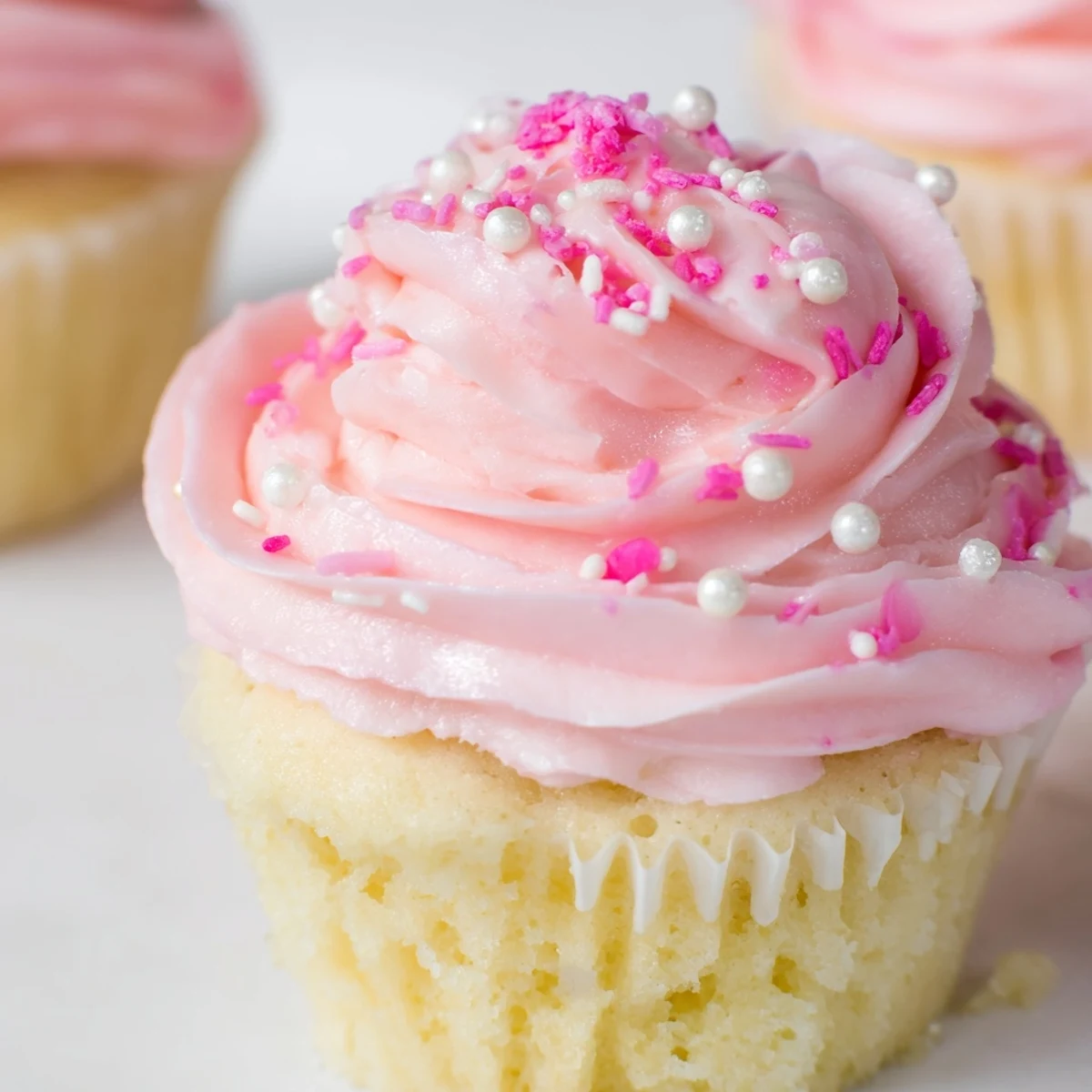 Moist vanilla Girl Baby Shower Cupcakes topped with pastel pink buttercream swirls, perfect for a baby girl celebration.