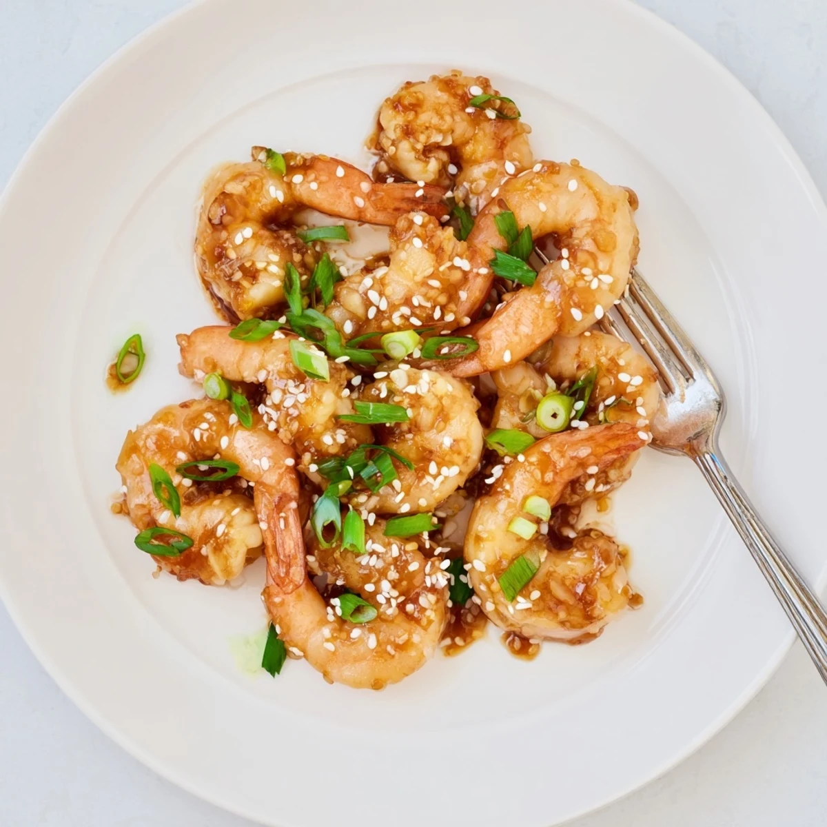 Juicy shrimp in High Protein Honey Garlic Shrimp glaze with fresh green onions on white rice.