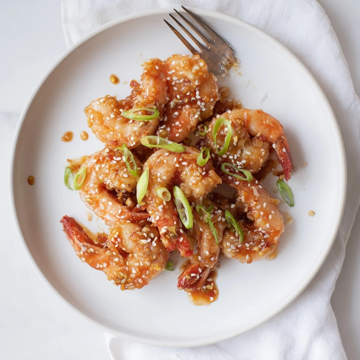 Close-up of High Protein Honey Garlic Shrimp with sesame seeds and steamed broccoli on a plate.