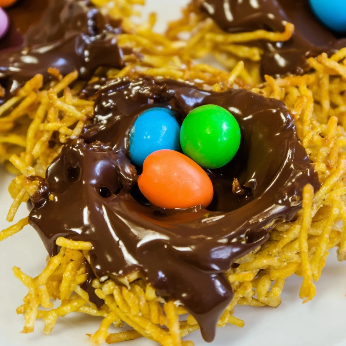 Easter Birds Nest Cookies with Peanut Butter and Chocolate arranged on a white plate, perfect for spring parties.