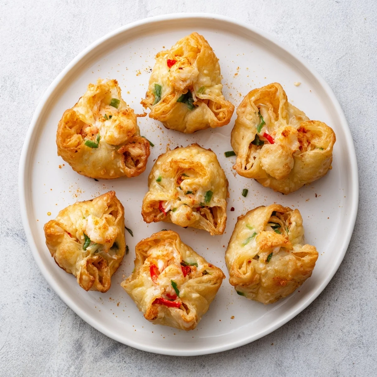 A close-up of Cheesy Seafood Tortilla Bombs garnished with parsley beside a dipping sauce.