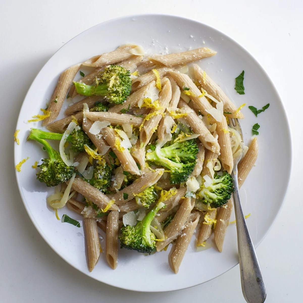 A close-up of Easy Healthy Broccoli Pasta on a white plate, featuring whole wheat penne tossed with bright green broccoli florets and a light olive oil sauce.