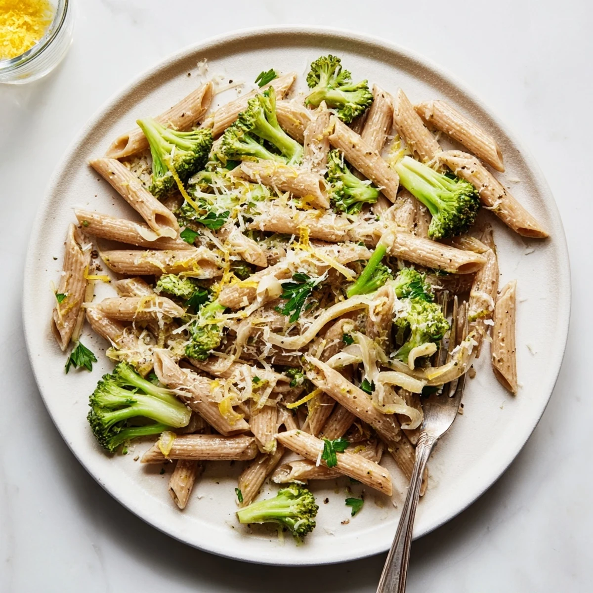 Overhead view of Easy Healthy Broccoli Pasta, showing tender broccoli and garlic mingling with pasta noodles in a shimmering lemon-infused olive oil sauce.