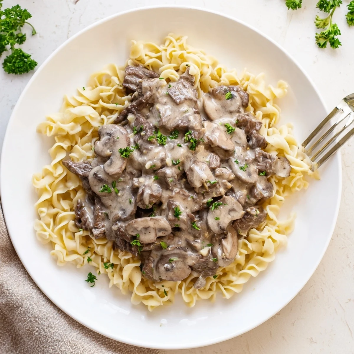 Creamy beef and mushroom stroganoff served over egg noodles with fresh parsley garnish