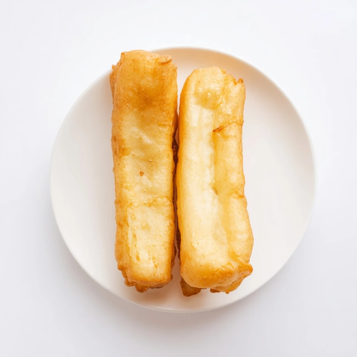 Golden brown Youtiao Chinese fried dough sticks cooling on wire rack after deep frying