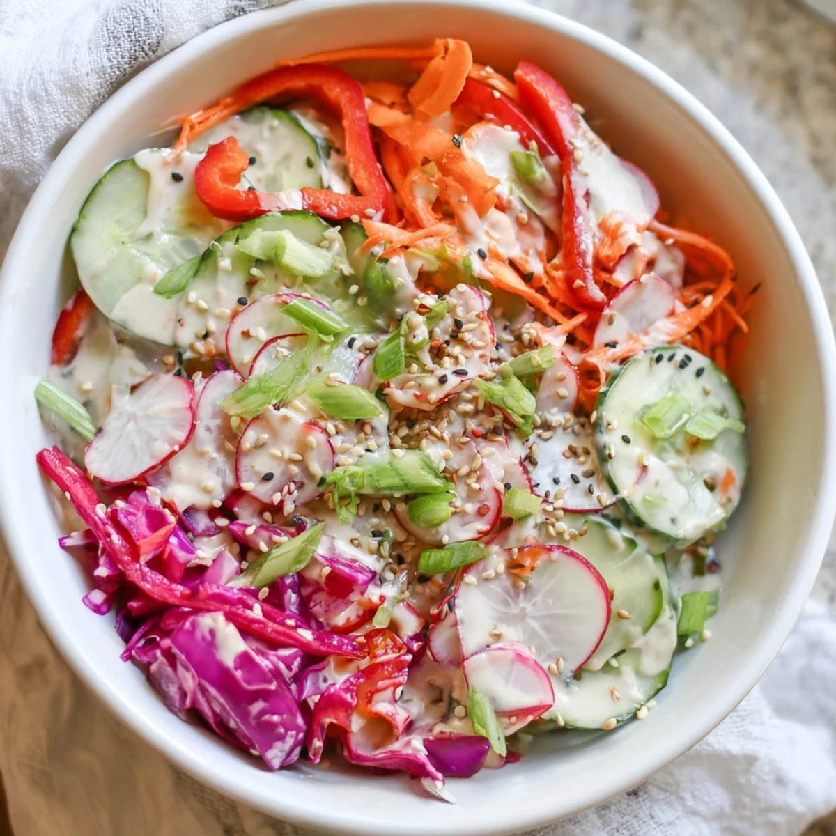 Fresh creamy Asian cucumber salad bowl with crisp vegetables and sesame dressing