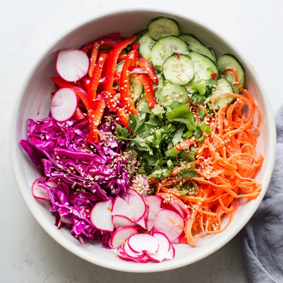 Vibrant creamy Asian cucumber salad bowl featuring julienned carrots and creamy dressing