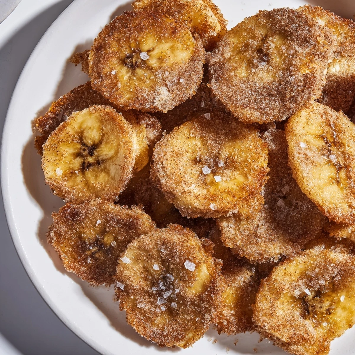 Homemade air fryer banana chips sprinkled with cinnamon sugar for healthy snacking