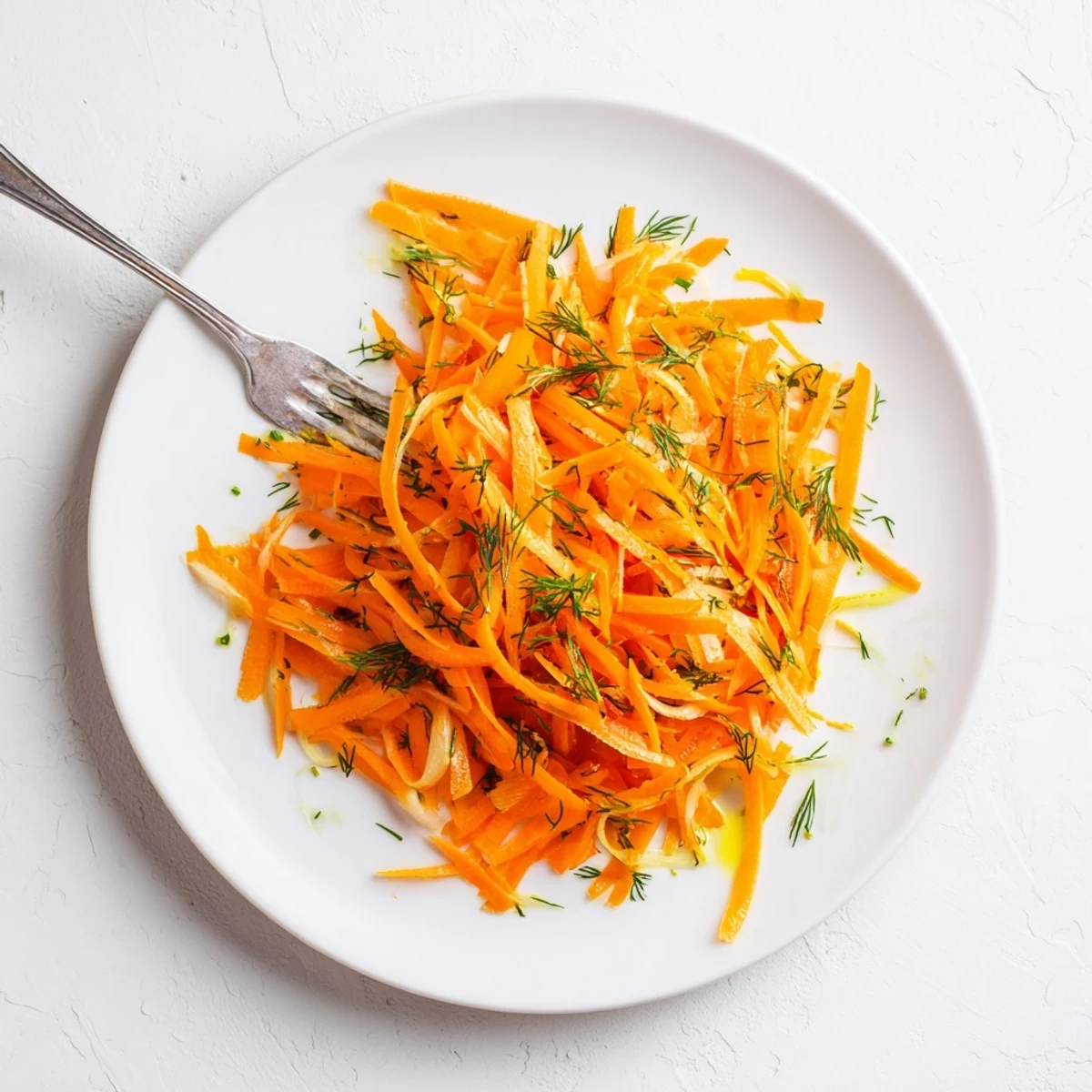 Bright lemon dill carrot salad topped with fresh herbs and scallion slices
