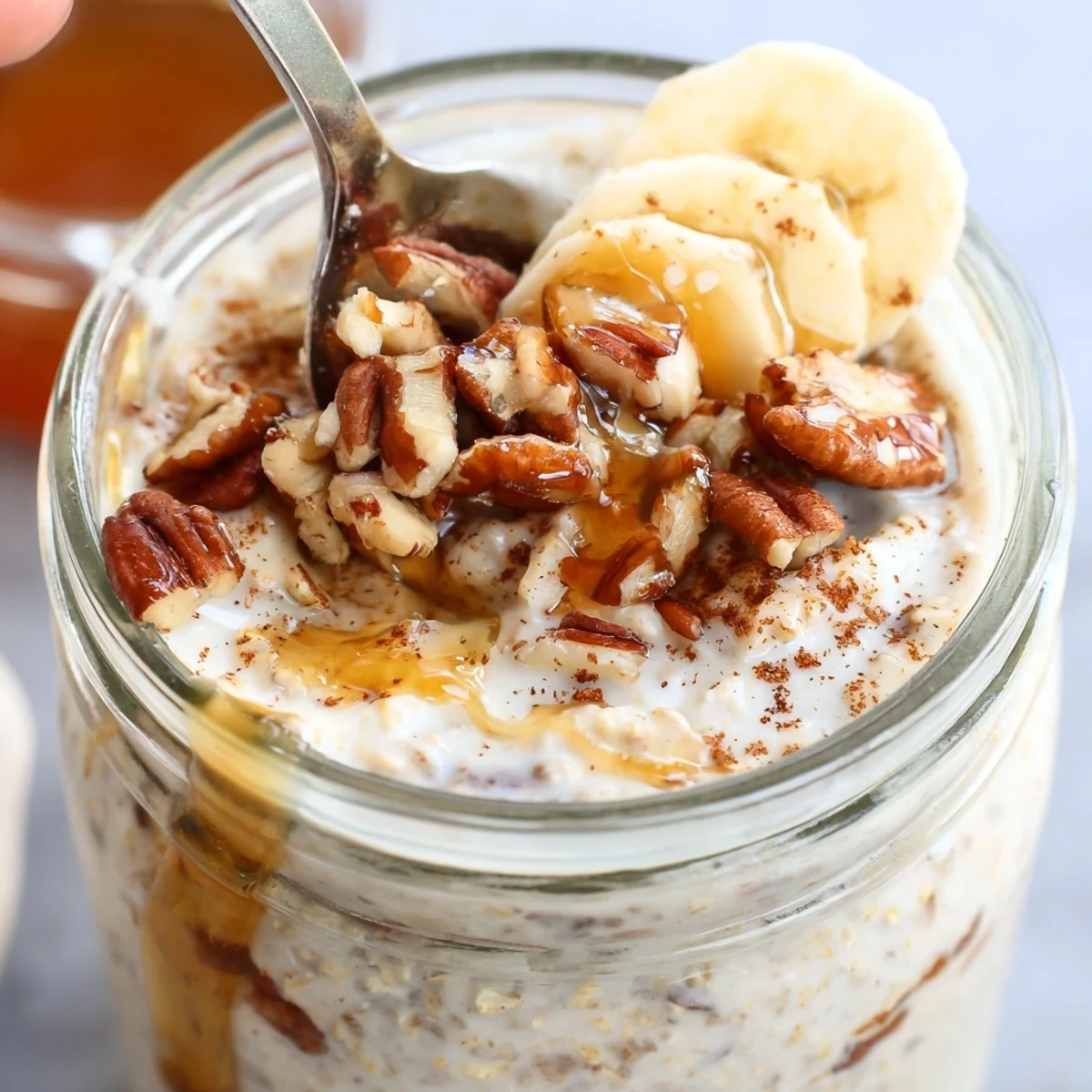 Maple cinnamon pecan overnight oats served chilled with a drizzle of sweet syrup