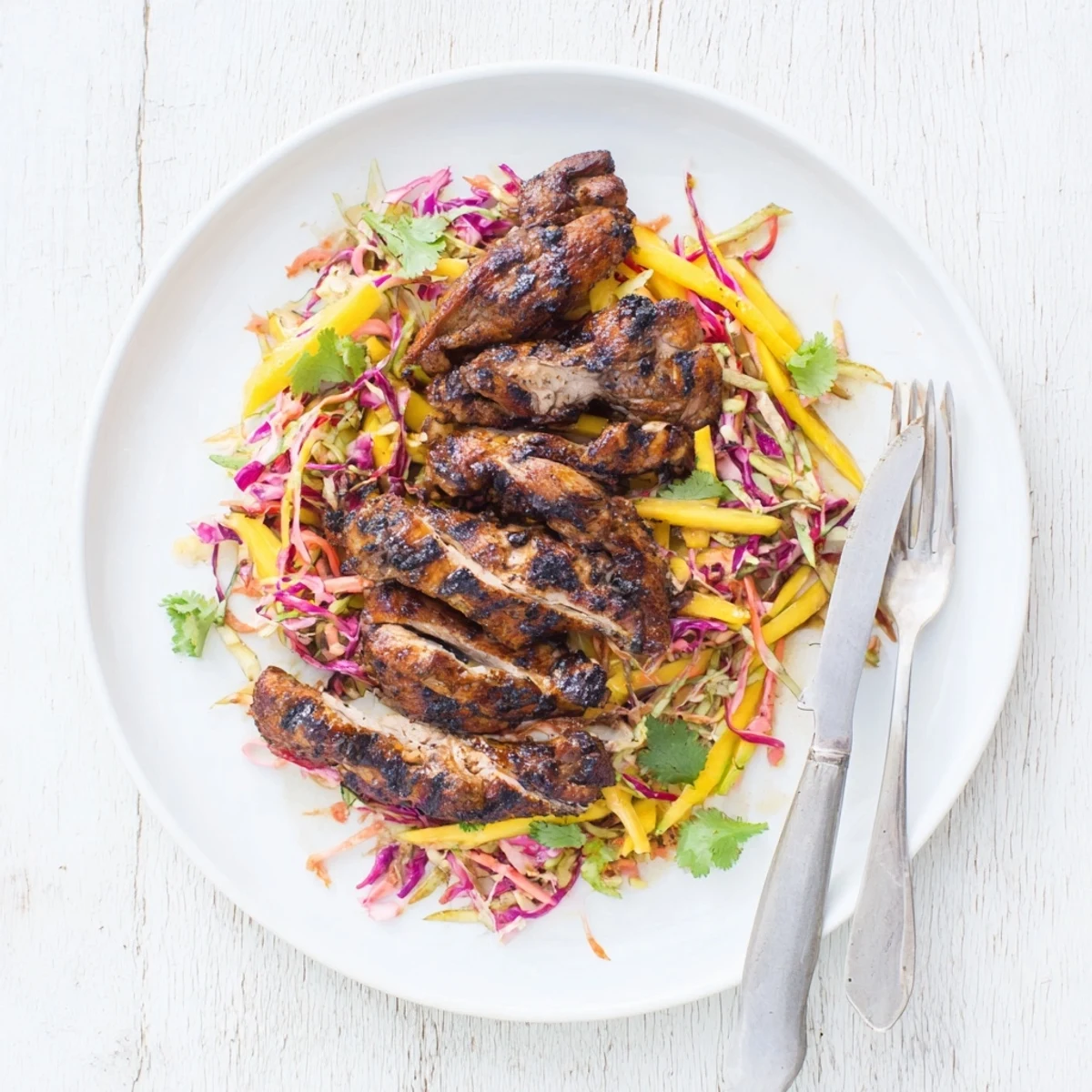 Grilled spicy jerk chicken paired with crisp sweet mango slaw