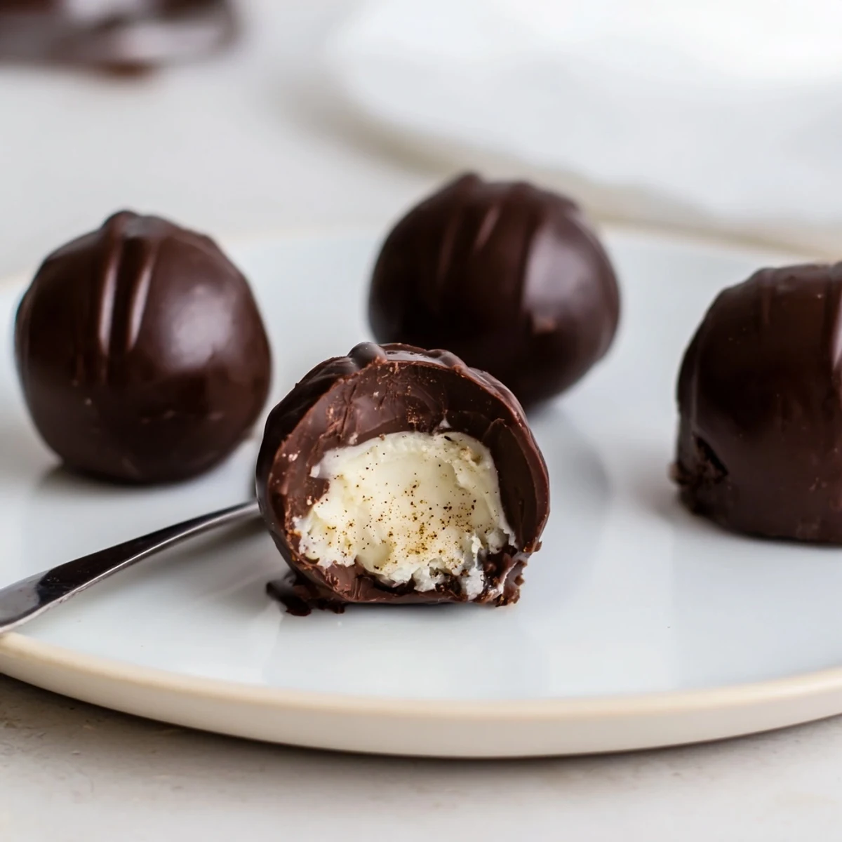 Plump Dark Chocolate Eggnog Truffles arranged on a tray, creamy centers promised.