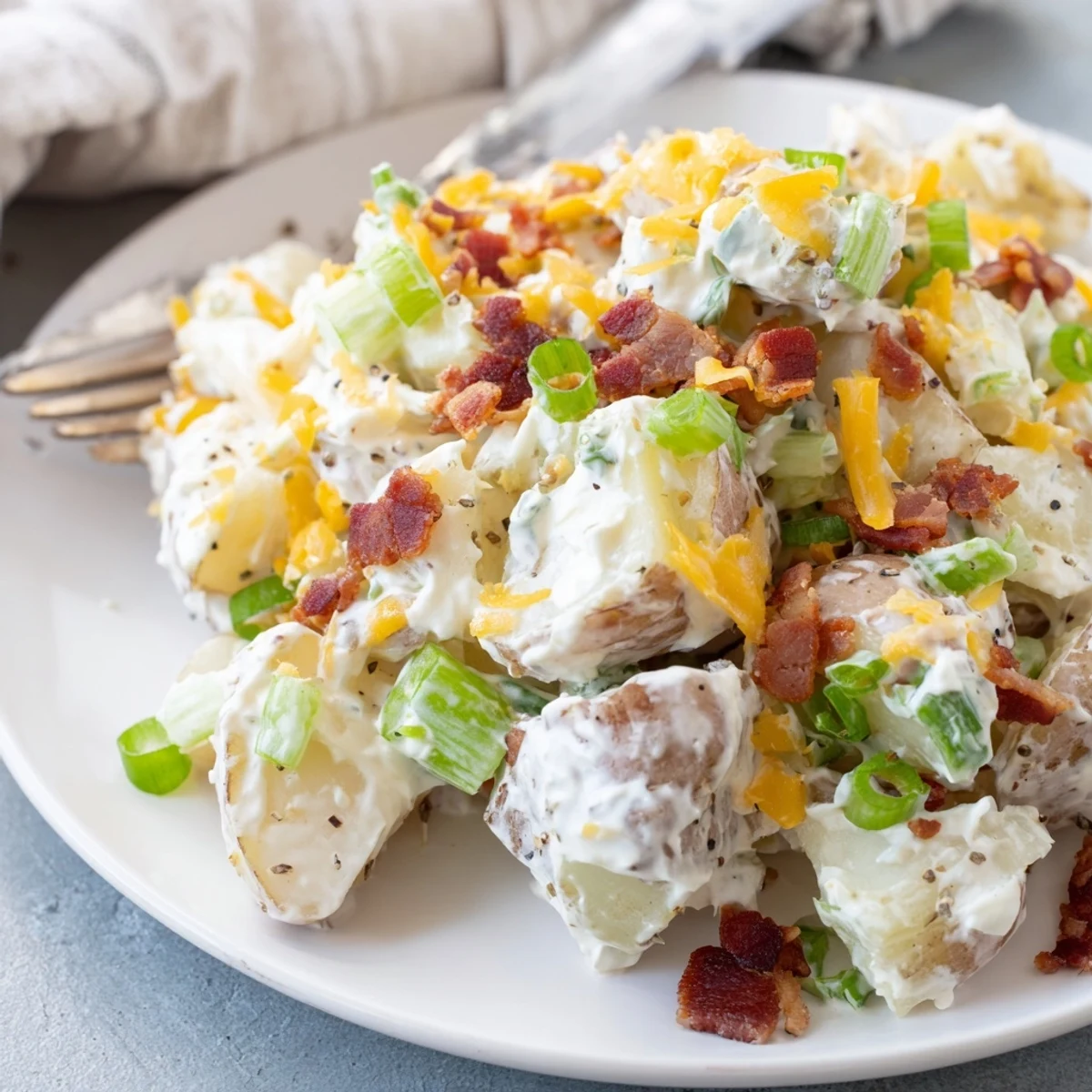 Warm Beef Bacon Loaded Potato Salad with crispy texture, cheddar, and chives  