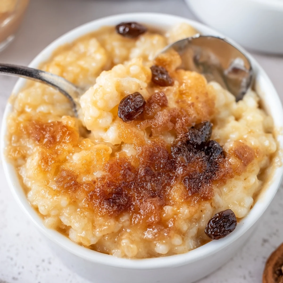 Spoon lifting warm Delicious Condensed Milk Baked Rice Pudding Recipe To Try, creamy center