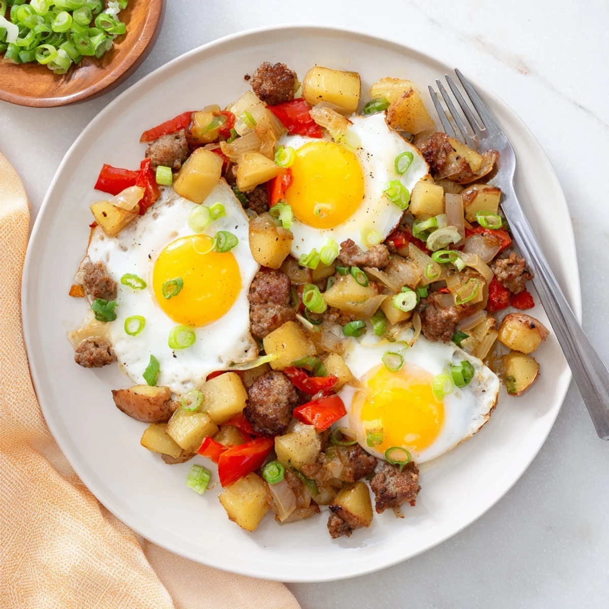 Golden Cajun beef sausage breakfast hash with crispy potatoes and perfectly cooked sunny-side up eggs in a cast iron skillet
