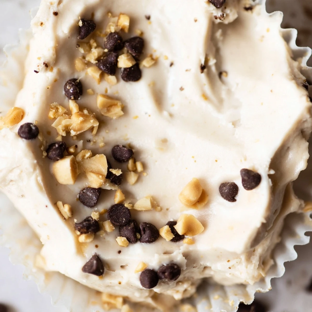 Creamy high protein frozen peanut butter Greek yogurt bites topped with melted dark chocolate and crushed peanuts in a mini muffin tin