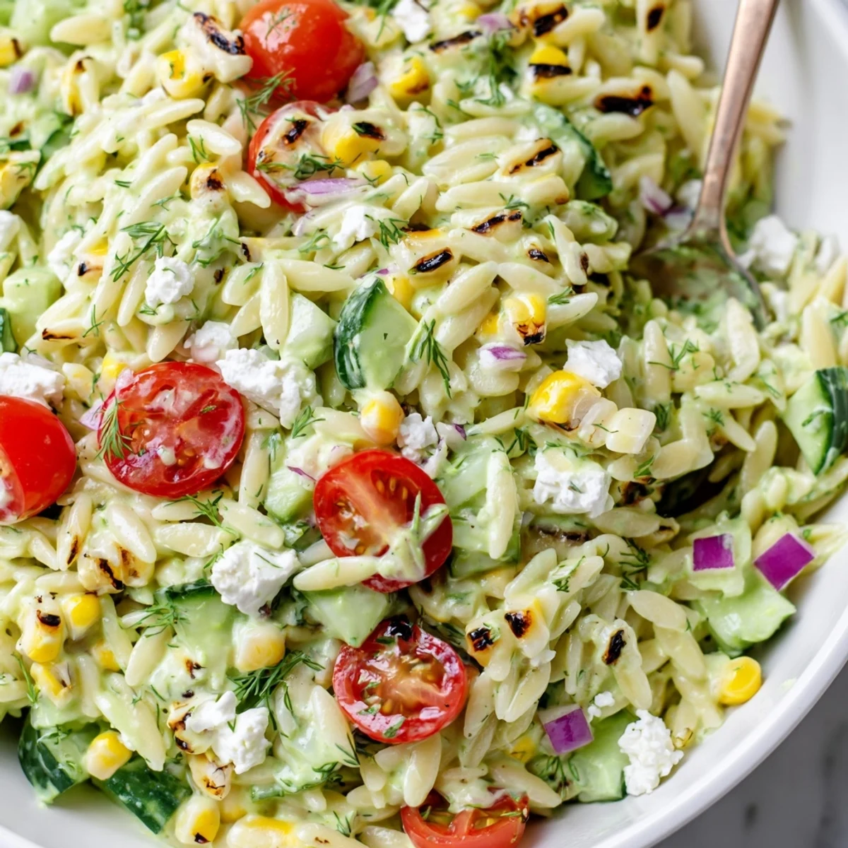Grilled corn orzo salad with scallion dill dressing in a rustic white bowl