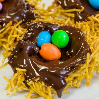 Easter Birds Nest Cookies with Peanut Butter and Chocolate arranged on a white plate, perfect for spring parties.